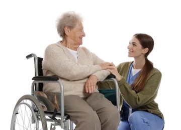 Caregiver assisting senior woman in wheelchair on white background. Home health care service