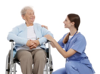 Caregiver assisting senior woman in wheelchair on white background. Home health care service