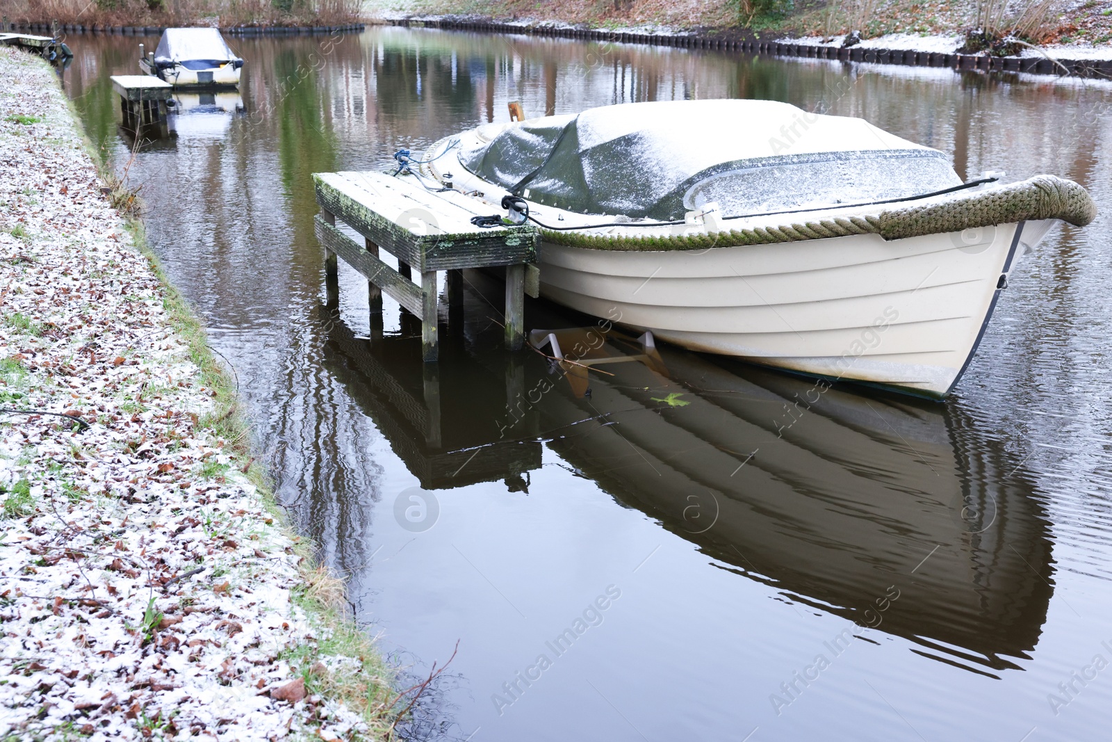 Photo of Water canal with moored boats on winter day