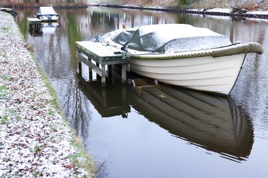 Water canal with moored boats on winter day