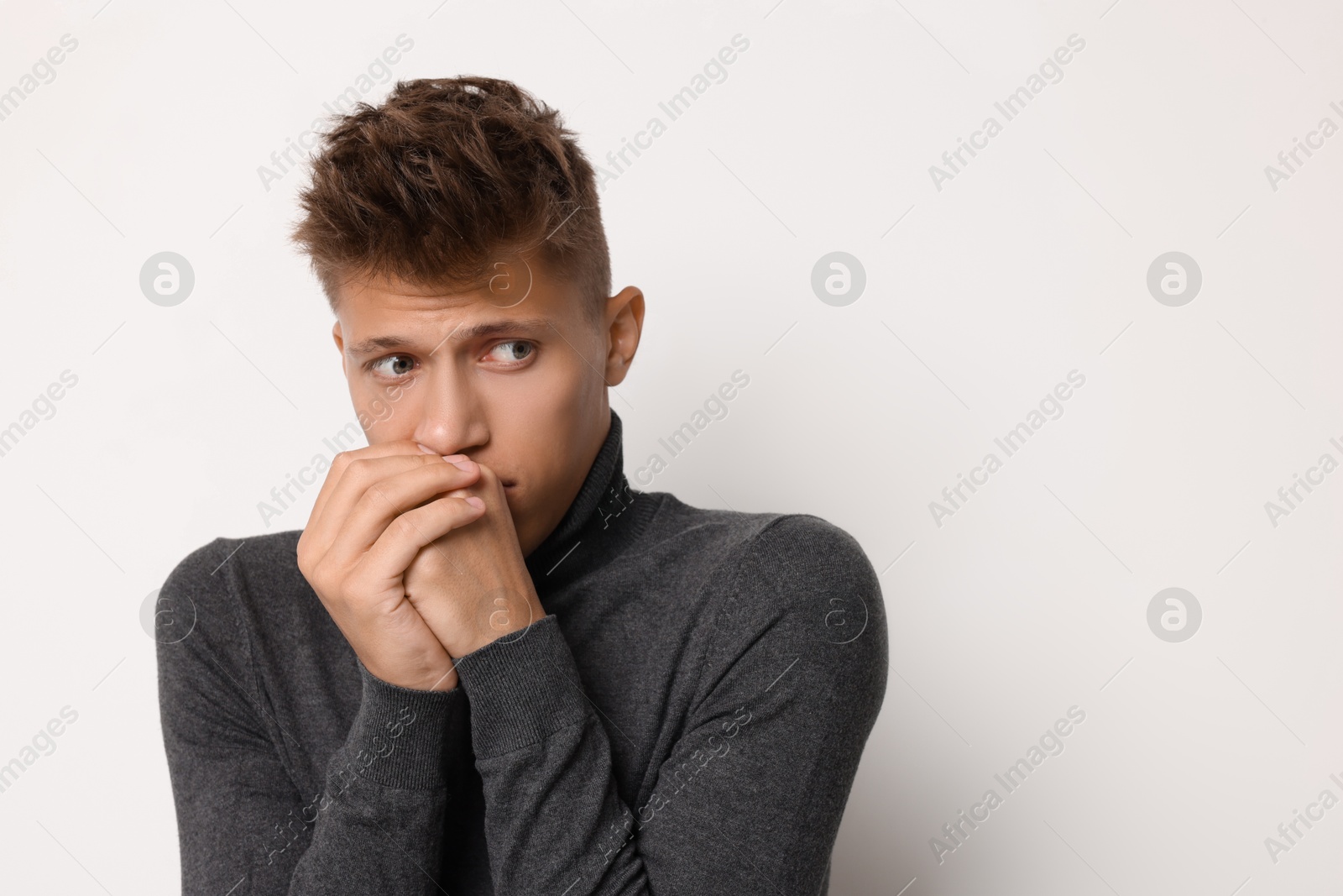 Photo of Portrait of scared young man on light background, space for text