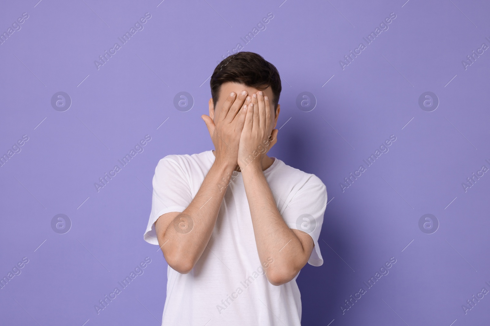 Photo of Portrait of scared young man on violet background