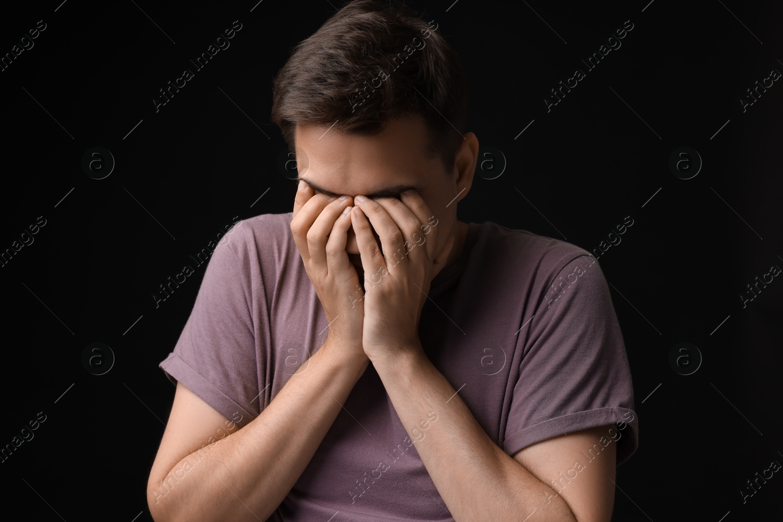 Photo of Portrait of scared young man on black background