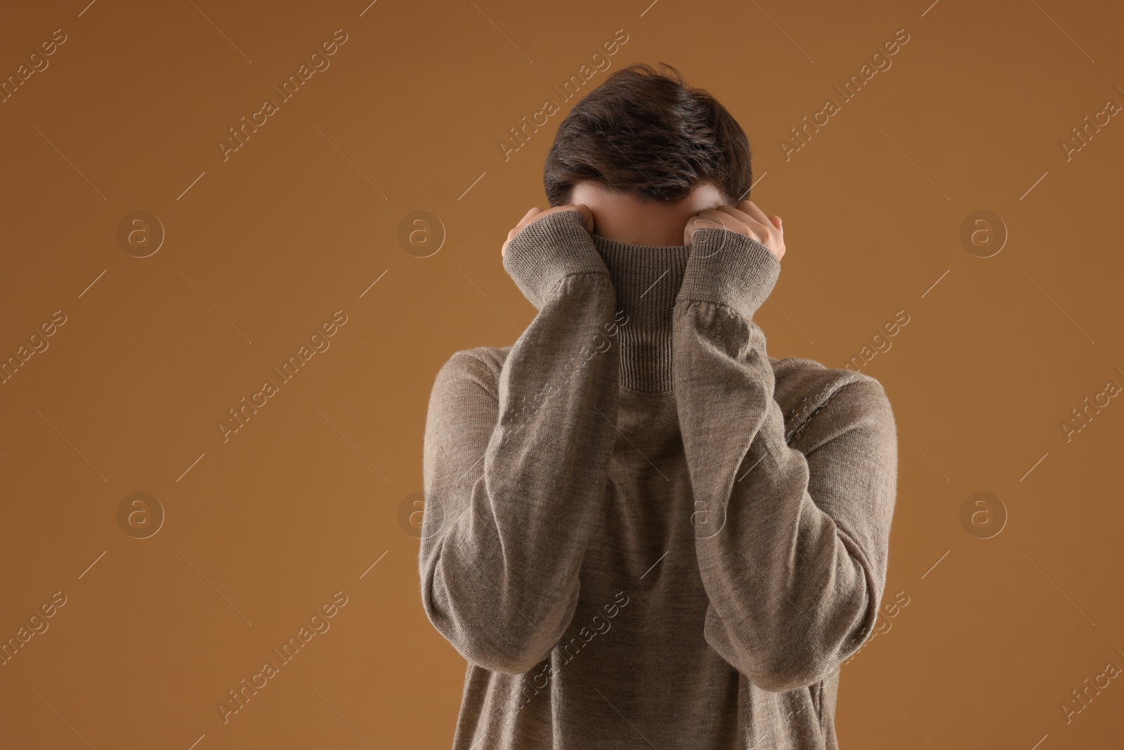 Photo of Portrait of scared young man on brown background