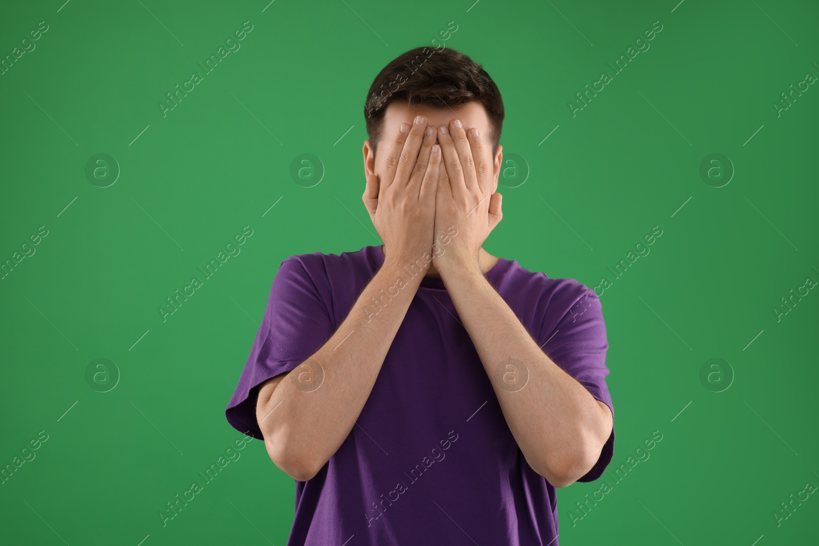 Photo of Portrait of scared young man on green background