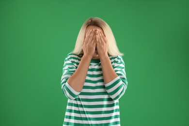 Portrait of scared woman on green background