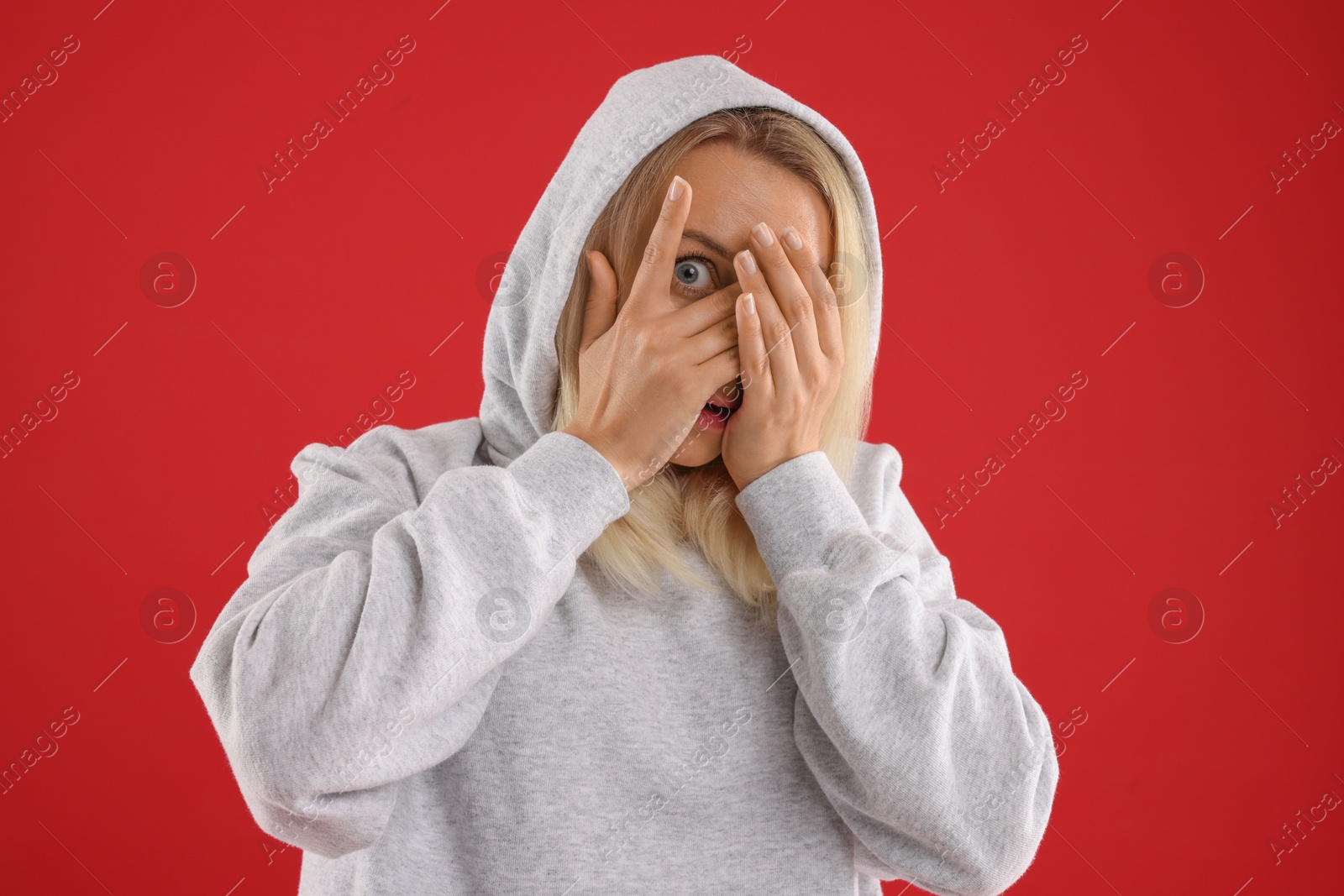 Photo of Portrait of scared woman on red background