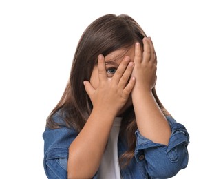 Photo of Scared little girl covering face with hands on white background