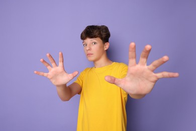 Photo of Portrait of scared teenage boy on violet background