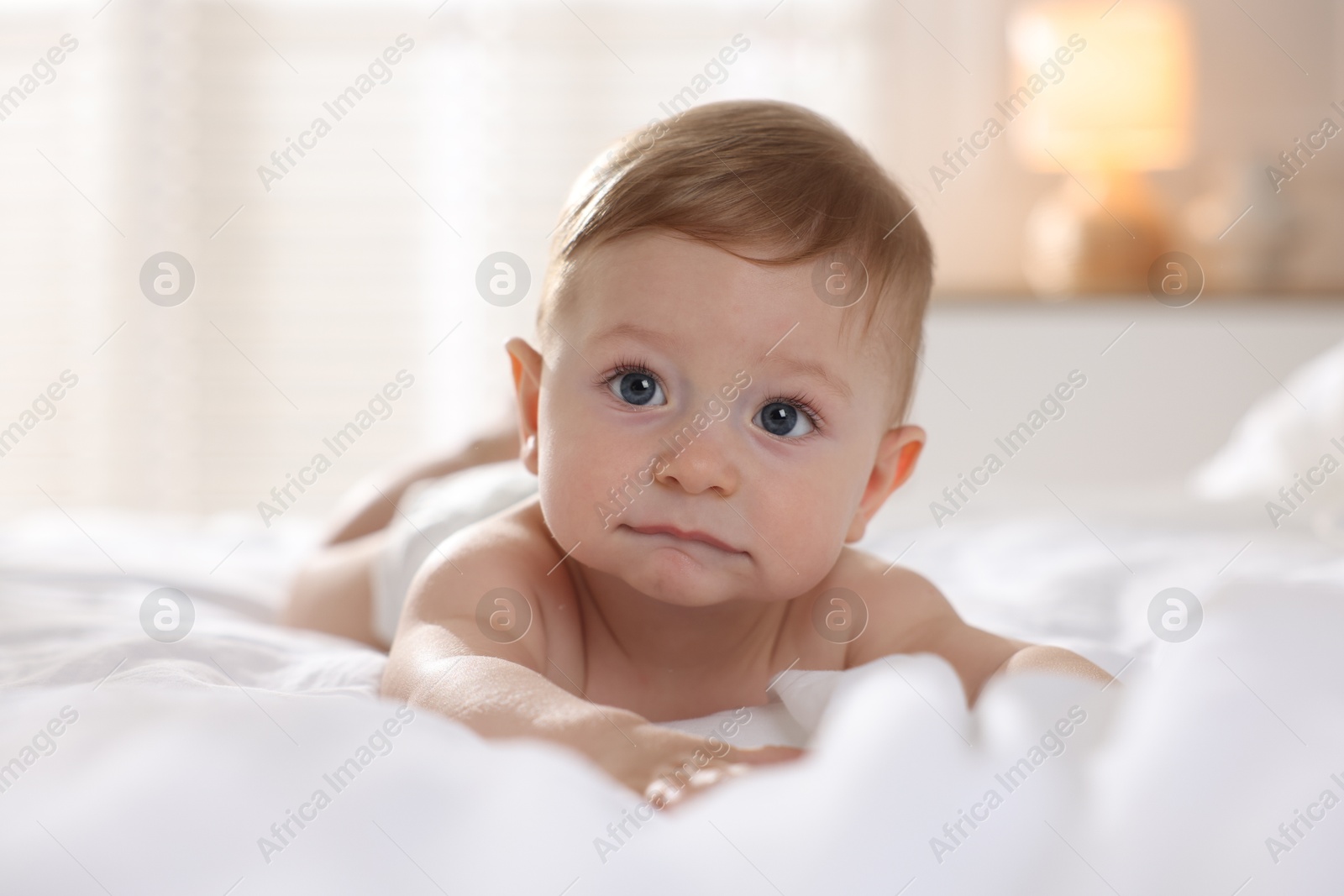 Photo of Cute baby lying on bed at home