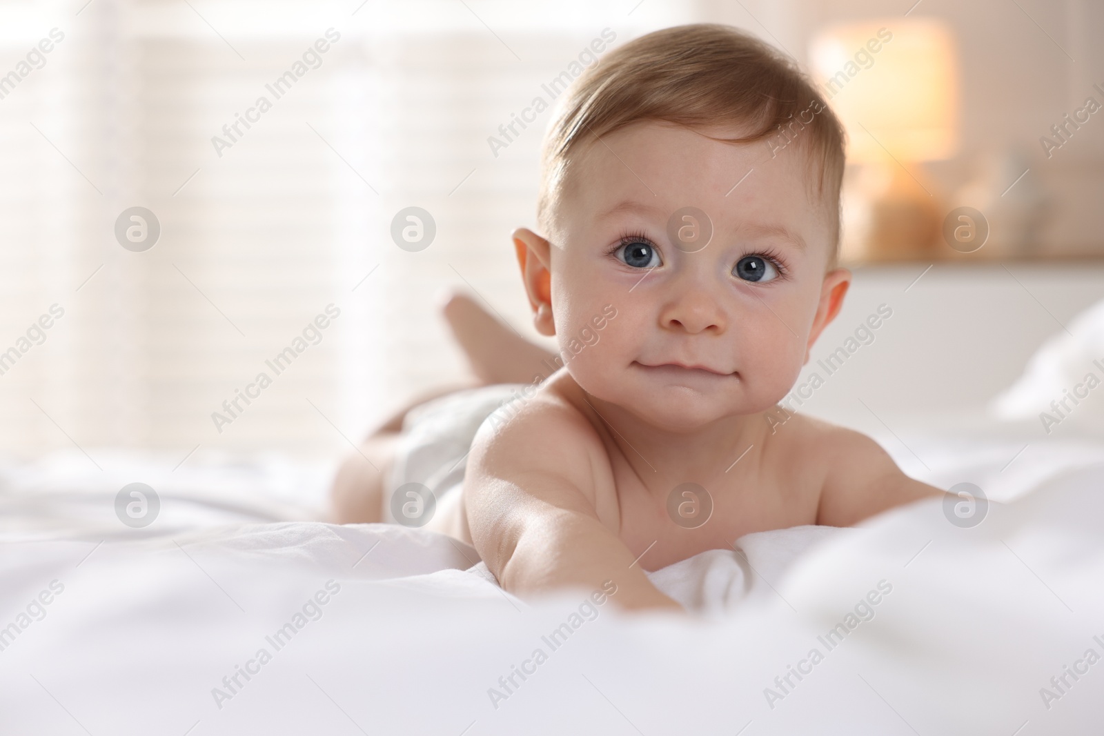 Photo of Cute baby lying on bed at home