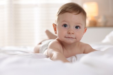 Photo of Cute baby lying on bed at home