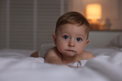 Cute baby lying on bed at home