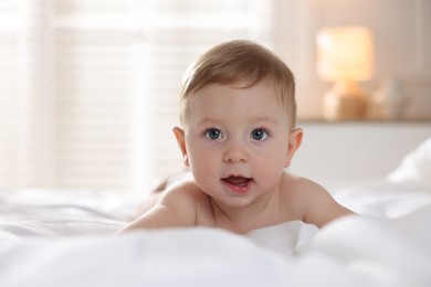 Photo of Cute baby lying on bed at home