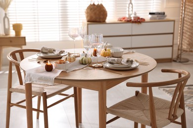 Photo of Stylish table setting with beautiful dishware and autumn decor in dining room