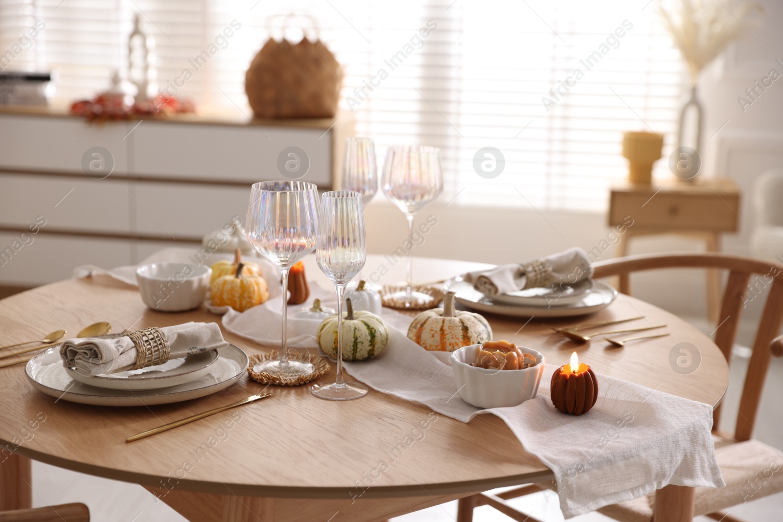 Photo of Stylish table setting with beautiful dishware and autumn decor in dining room