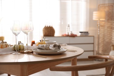 Photo of Stylish table setting with beautiful dishware and autumn decor in dining room