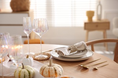 Stylish table setting with beautiful dishware and autumn decor in dining room