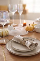 Photo of Stylish table setting with beautiful dishware and autumn decor in dining room, closeup