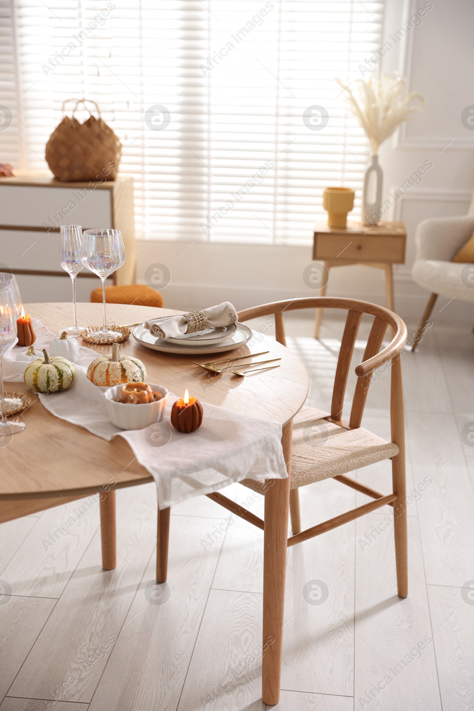 Photo of Stylish table setting with beautiful dishware and autumn decor in dining room