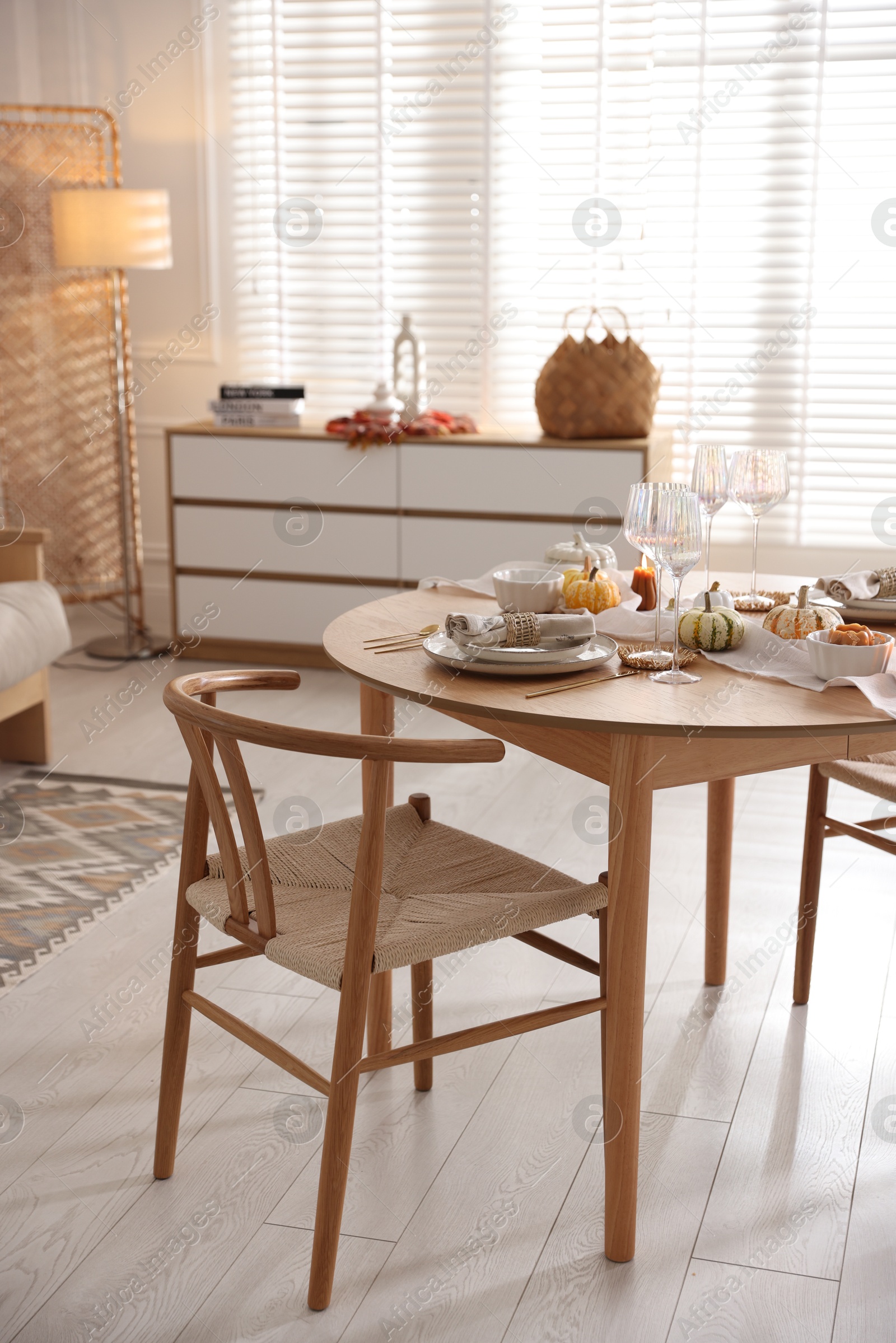 Photo of Stylish table setting with beautiful dishware and autumn decor in dining room