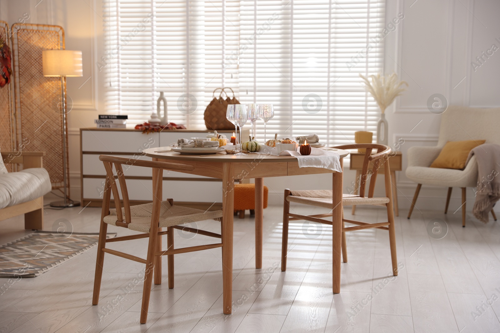 Photo of Stylish table setting with beautiful dishware and autumn decor in dining room