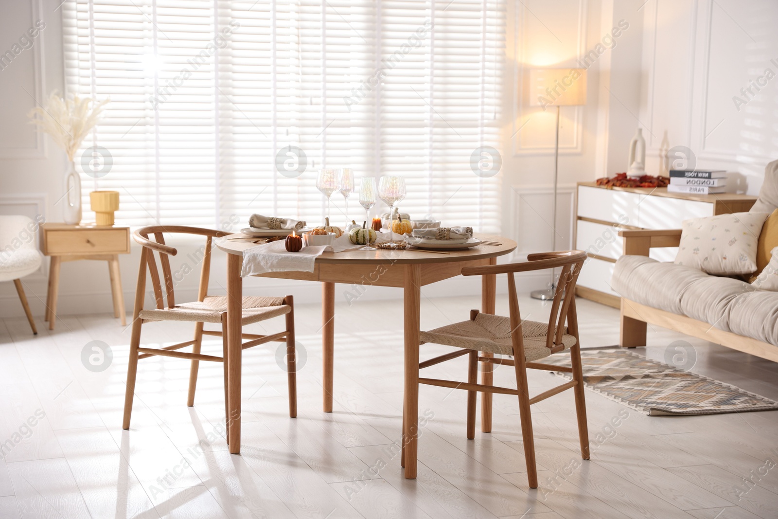 Photo of Stylish table setting with beautiful dishware and autumn decor in dining room