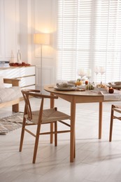 Photo of Stylish table setting with beautiful dishware and autumn decor in dining room