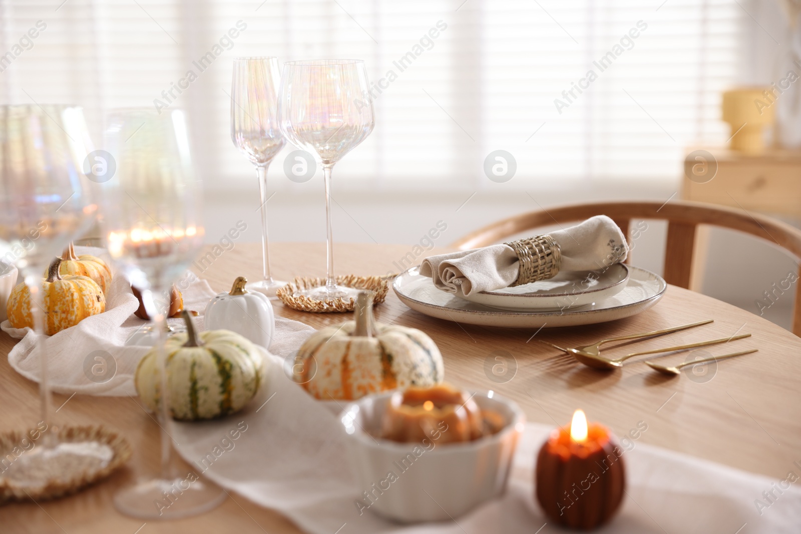 Photo of Stylish table setting with beautiful dishware and autumn decor in dining room