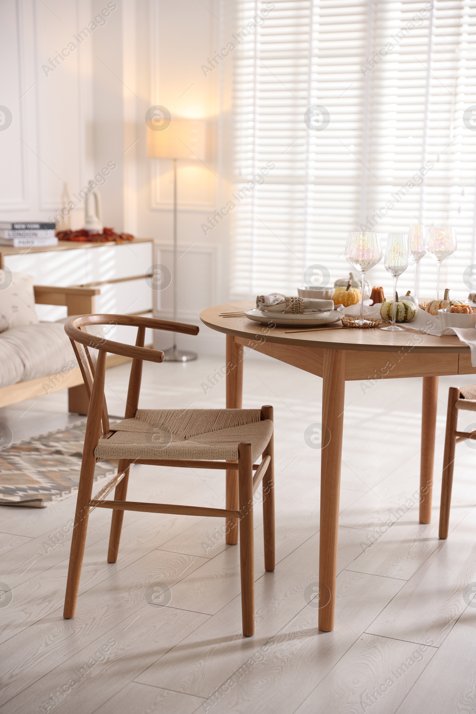 Photo of Stylish table setting with beautiful dishware and autumn decor in dining room