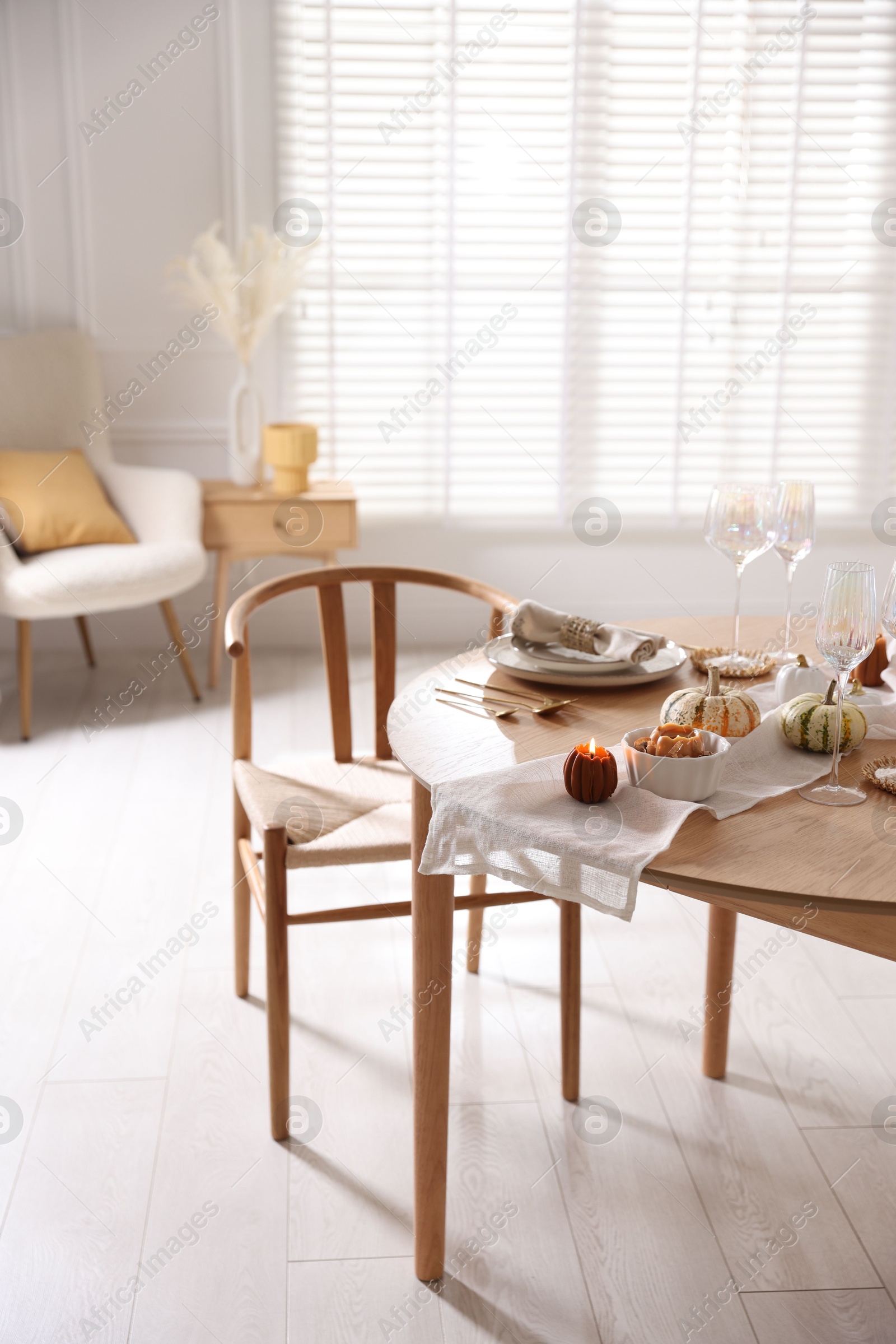 Photo of Stylish table setting with beautiful dishware and autumn decor in dining room