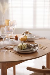 Stylish table setting with beautiful dishware and autumn decor in dining room