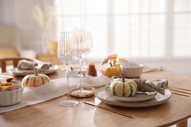 Photo of Stylish table setting with beautiful dishware and autumn decor in dining room