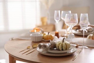 Photo of Stylish table setting with beautiful dishware and autumn decor in dining room