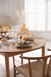 Photo of Stylish table setting with beautiful dishware and autumn decor in dining room