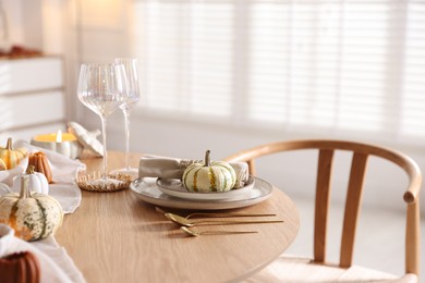 Stylish table setting with beautiful dishware and autumn decor in dining room