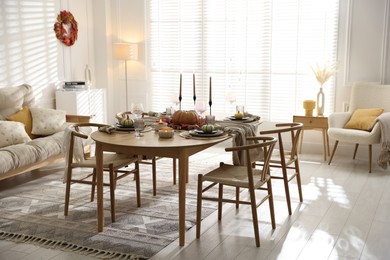 Stylish table setting with beautiful dishware and autumn decor in dining room