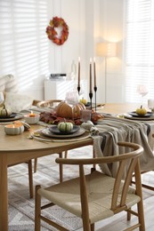 Stylish table setting with beautiful dishware and autumn decor in dining room