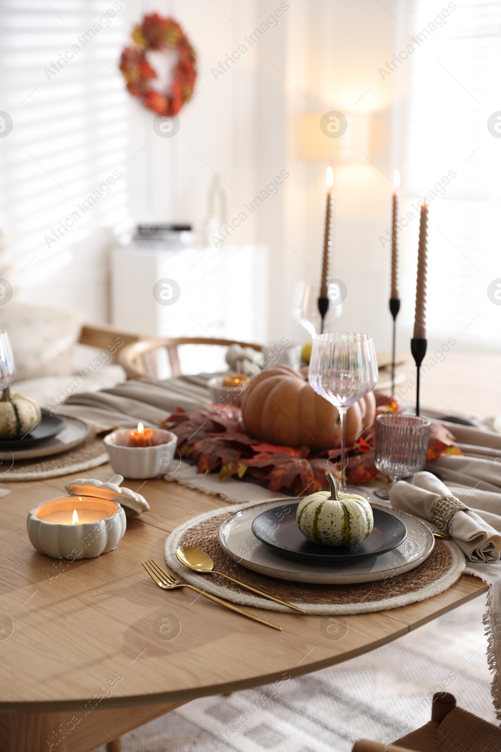 Photo of Stylish table setting with beautiful dishware and autumn decor in dining room