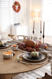 Stylish table setting with beautiful dishware and autumn decor in dining room