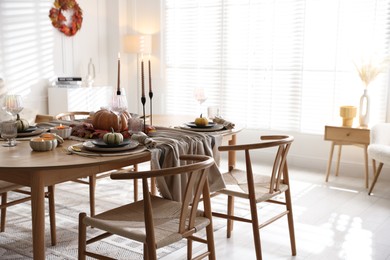 Photo of Stylish table setting with beautiful dishware and autumn decor in dining room