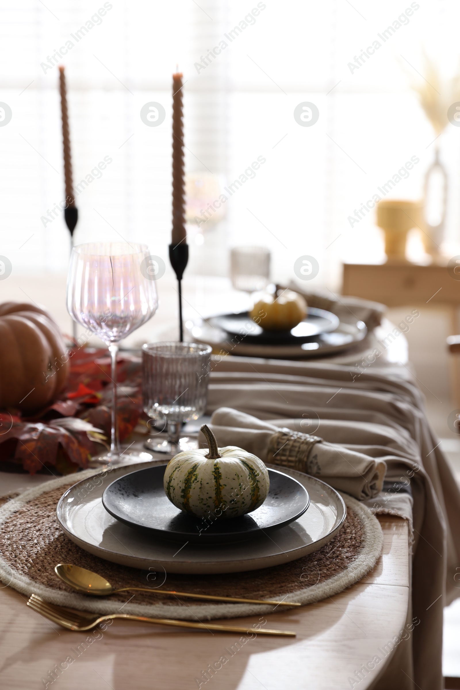 Photo of Stylish table setting with beautiful dishware and autumn decor in dining room