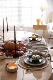 Photo of Stylish table setting with beautiful dishware and autumn decor in dining room