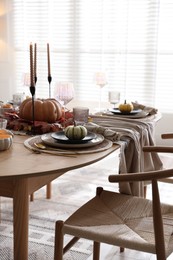 Photo of Stylish table setting with beautiful dishware and autumn decor in dining room