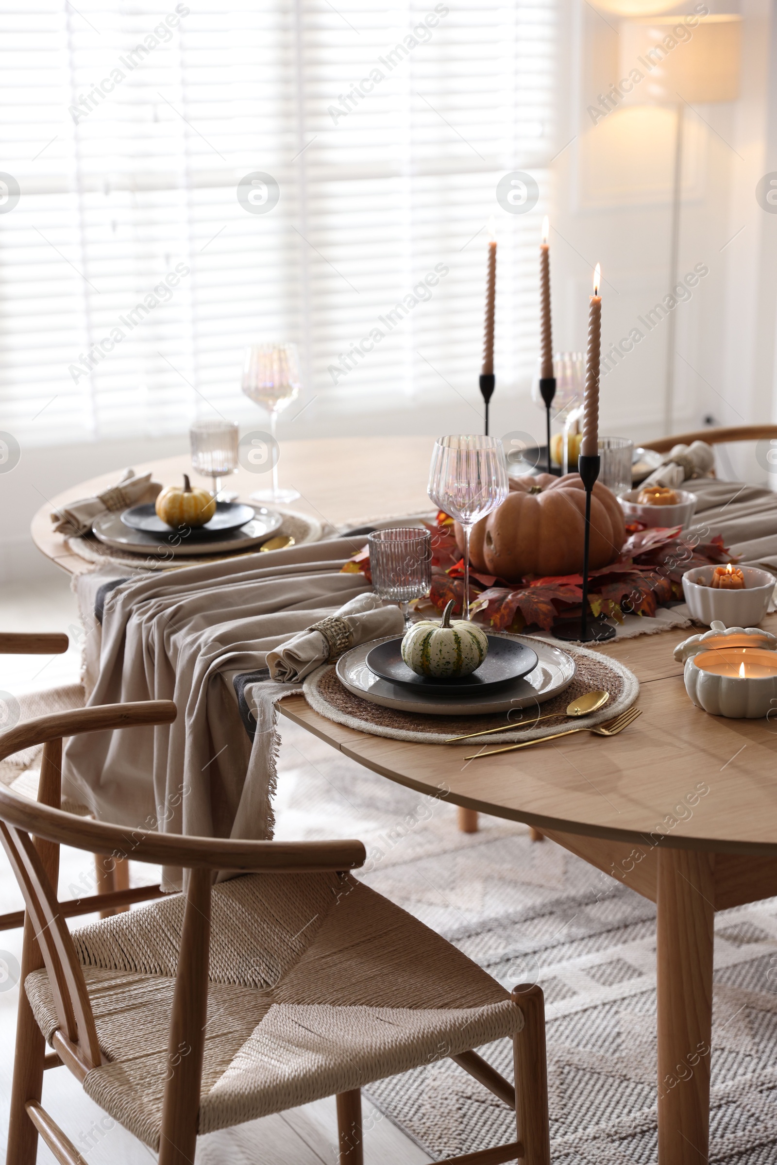 Photo of Stylish table setting with beautiful dishware and autumn decor in dining room