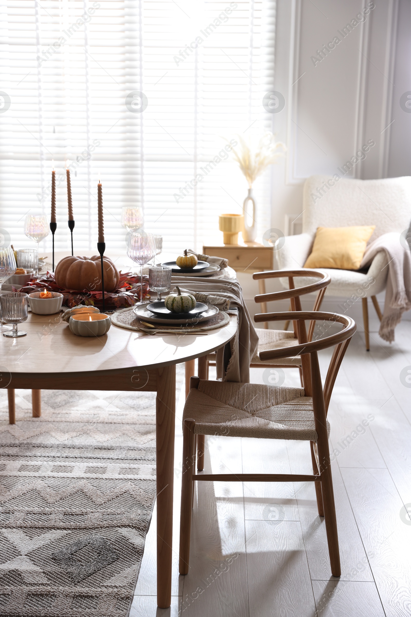 Photo of Stylish table setting with beautiful dishware and autumn decor in dining room