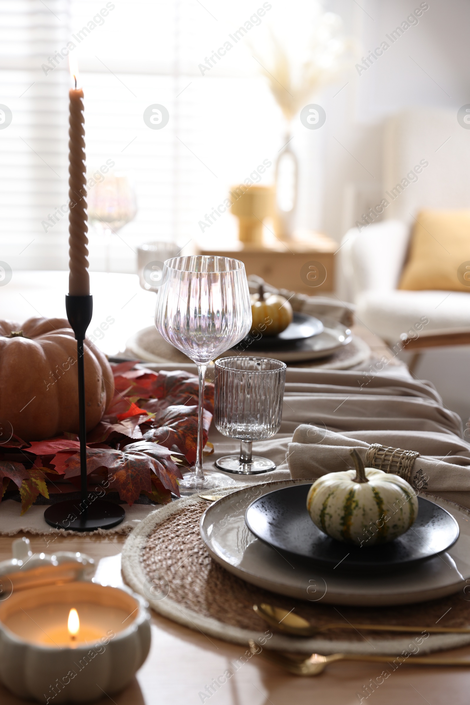 Photo of Stylish table setting with beautiful dishware and autumn decor in dining room