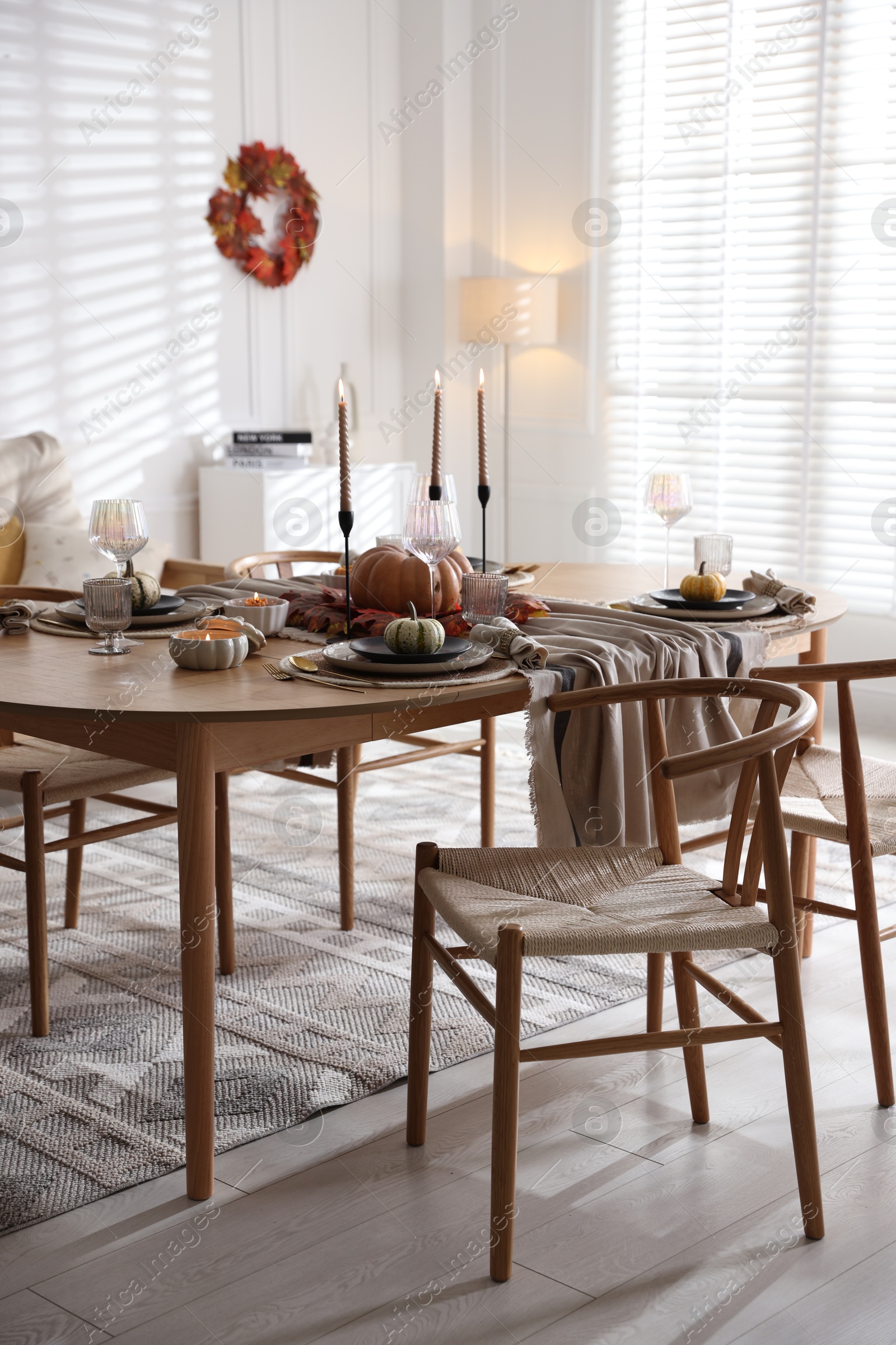 Photo of Stylish table setting with beautiful dishware and autumn decor in dining room