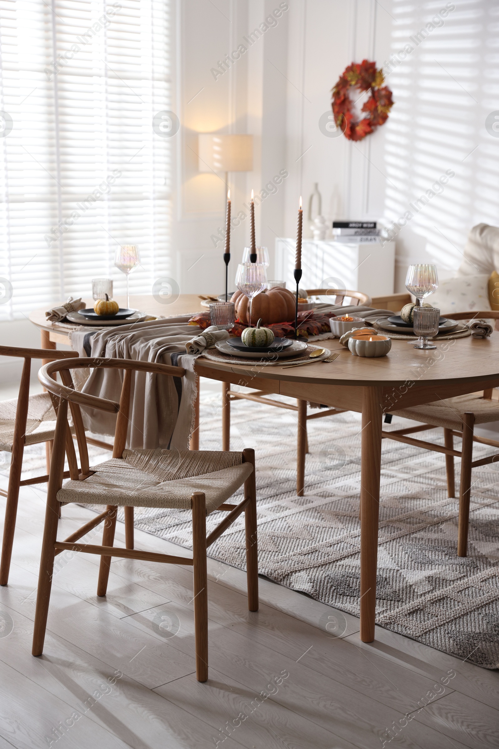 Photo of Stylish table setting with beautiful dishware and autumn decor in dining room