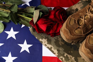 Photo of Veterans day. Roses and military uniform on American flag, flat lay